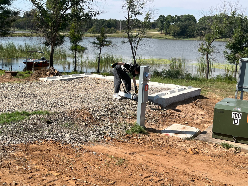 Student using a magnetic rake to pick up scrap metal.